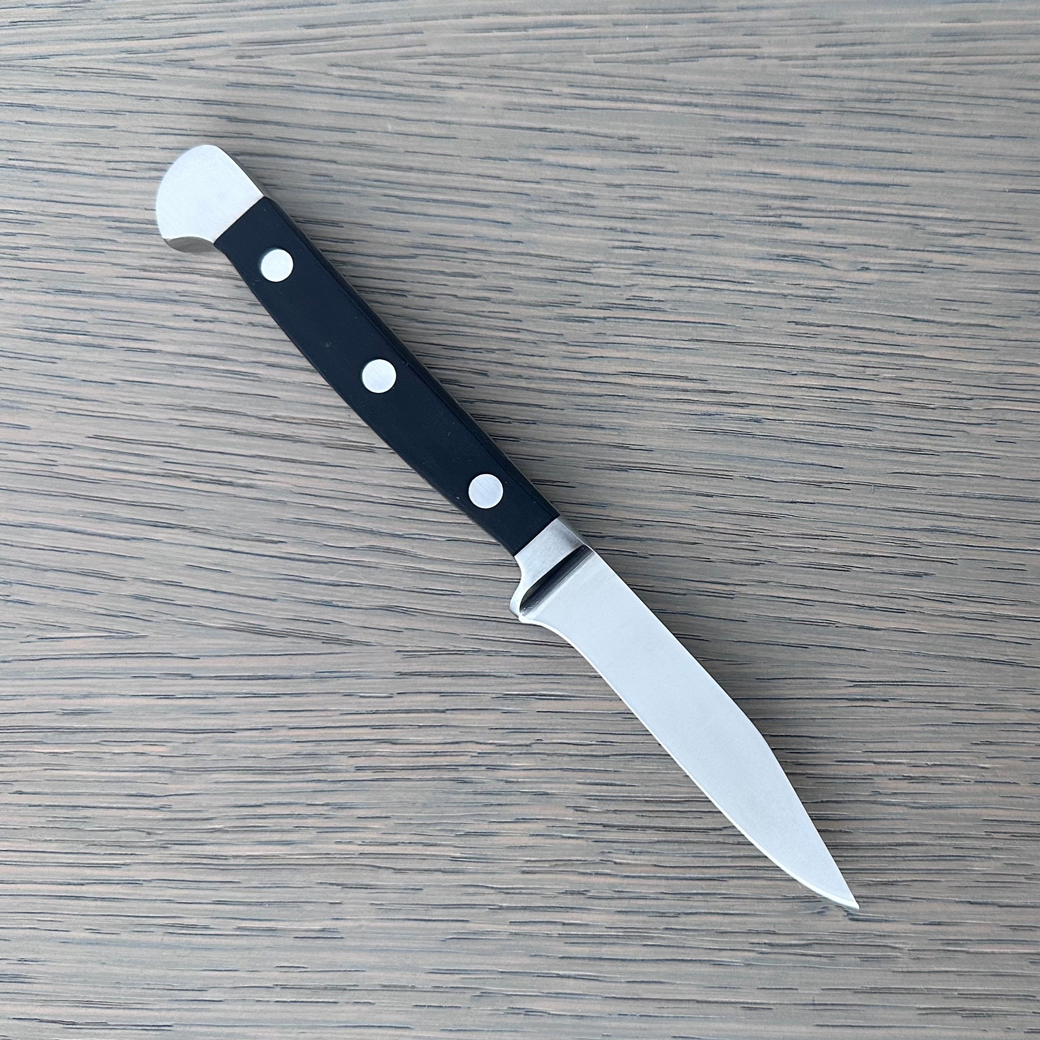 Güde Alpha Series 3-inch Sharp Point paring knife with a pointed tip and black Hostaform handle